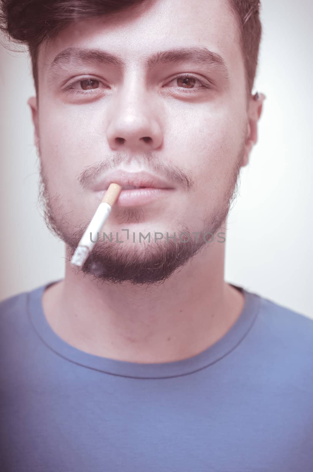 stylish young modern man with cigarette on vignetting background
