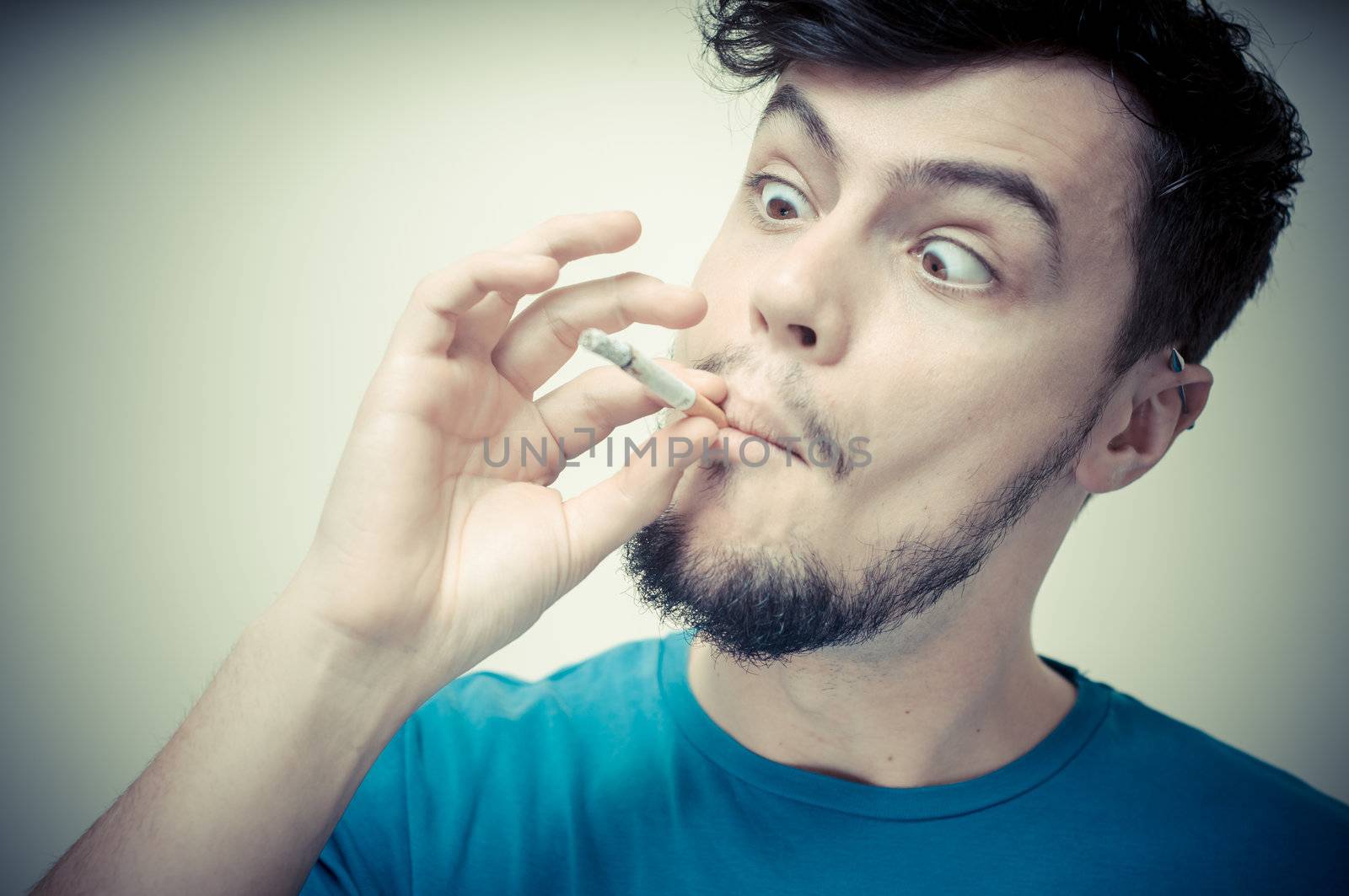 stylish young modern man with cigarette on vignetting background