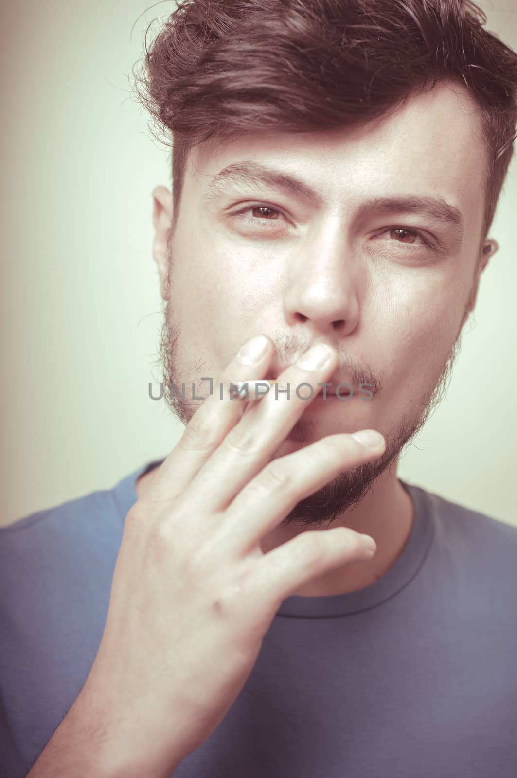stylish young modern man with cigarette on vignetting background