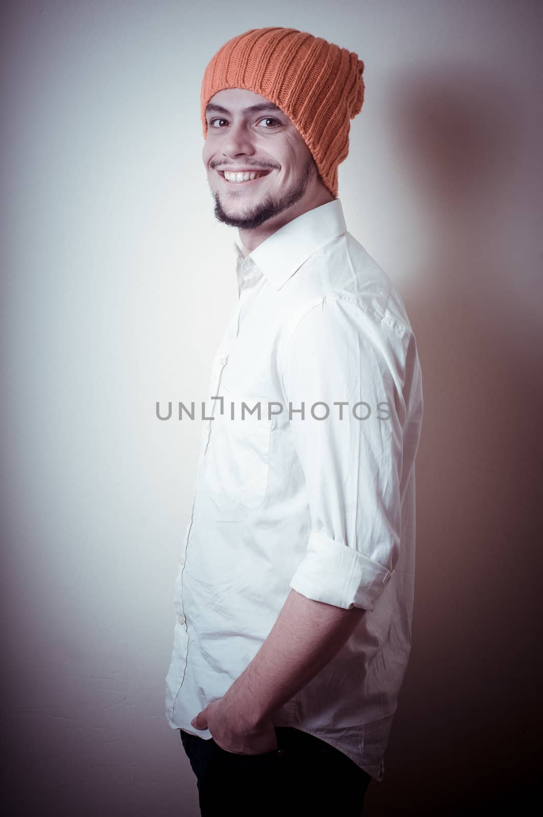 young modern stylish man with orange cap on vignetting background