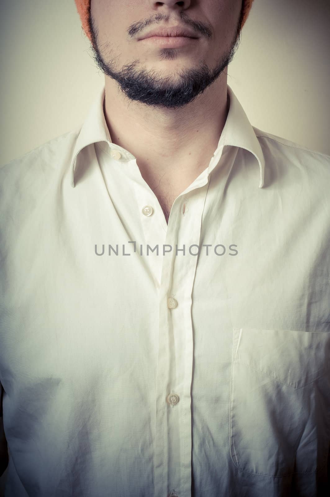 young modern stylish man with orange cap on vignetting background