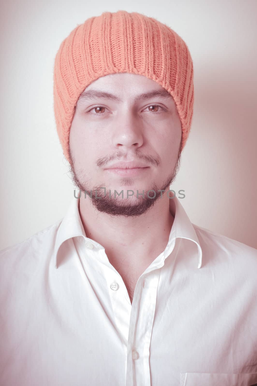 young modern stylish man with orange cap on vignetting background