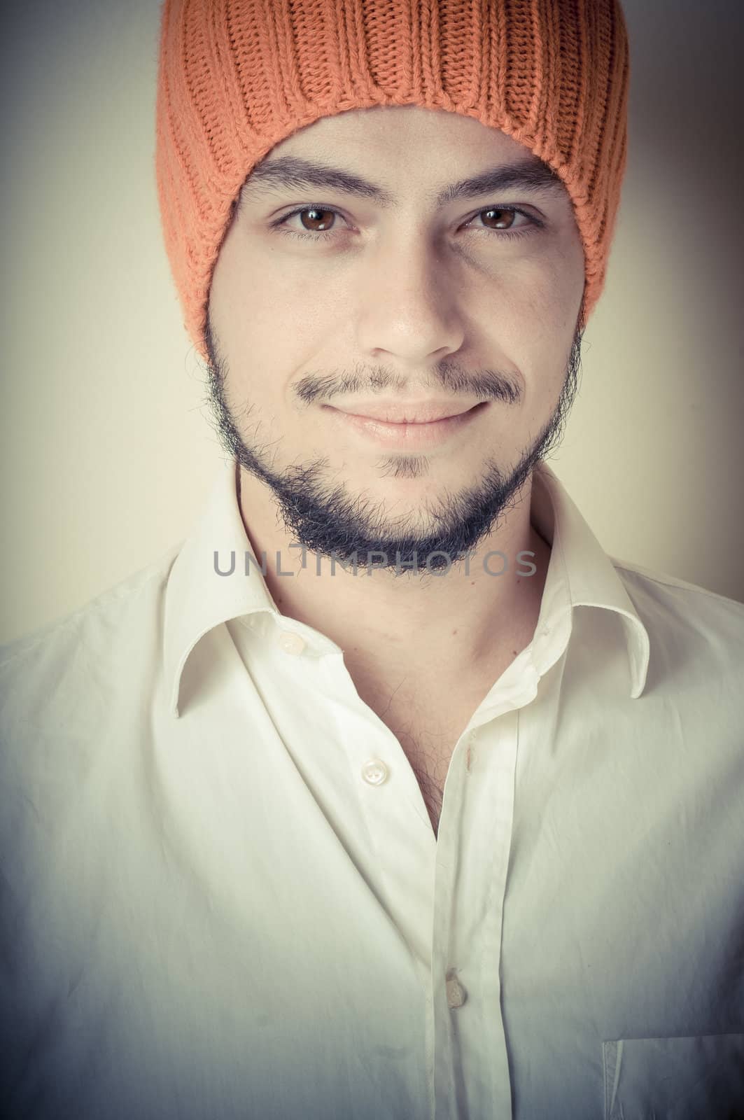 young modern stylish man with orange cap on vignetting background