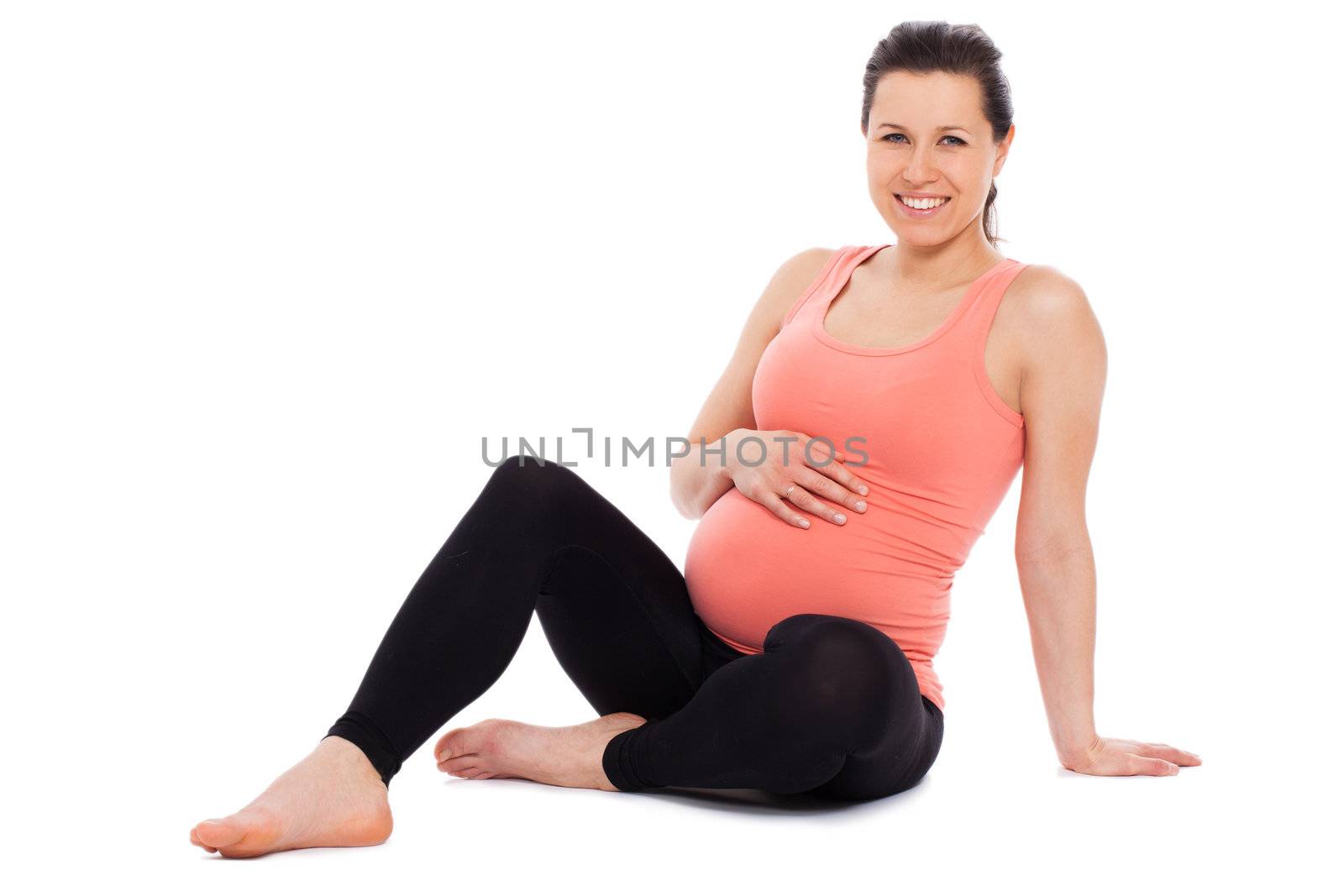 Beautiful pregnant woman sitting; isolated over white background