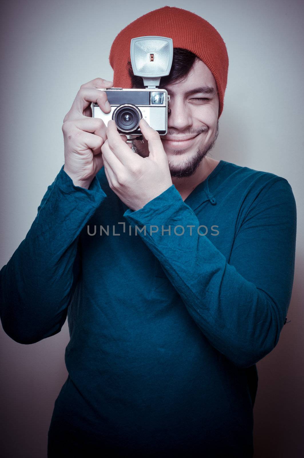 young stylish man holding old camera on vignetting background