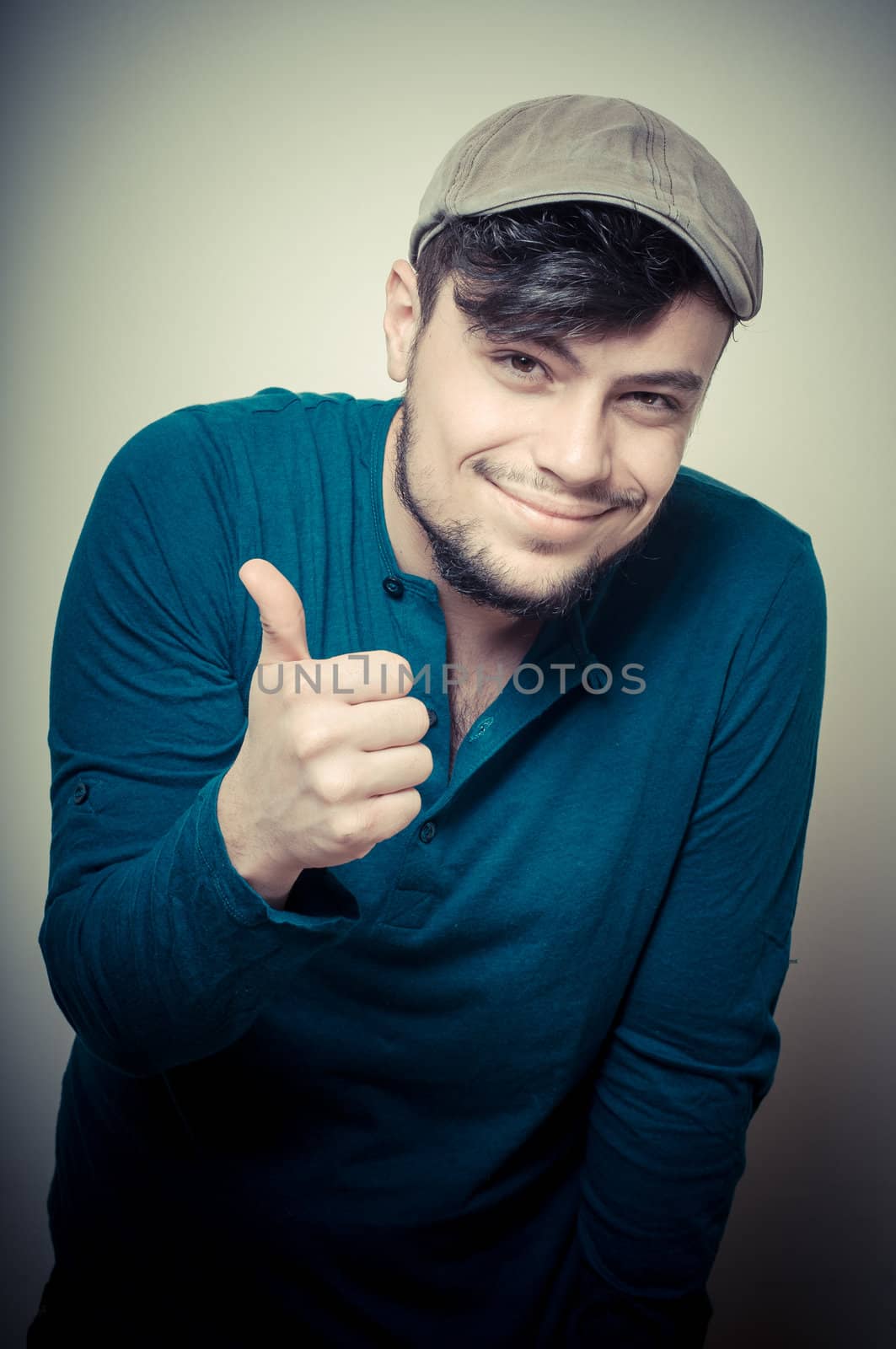 young modern stylish man with cap on vignetting background