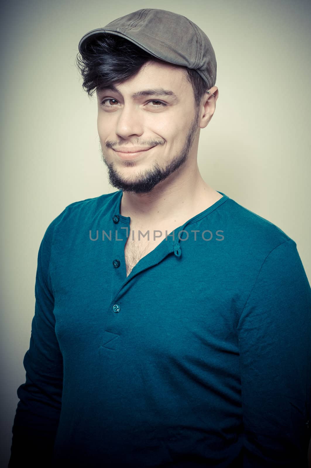 young modern stylish man with cap on vignetting background