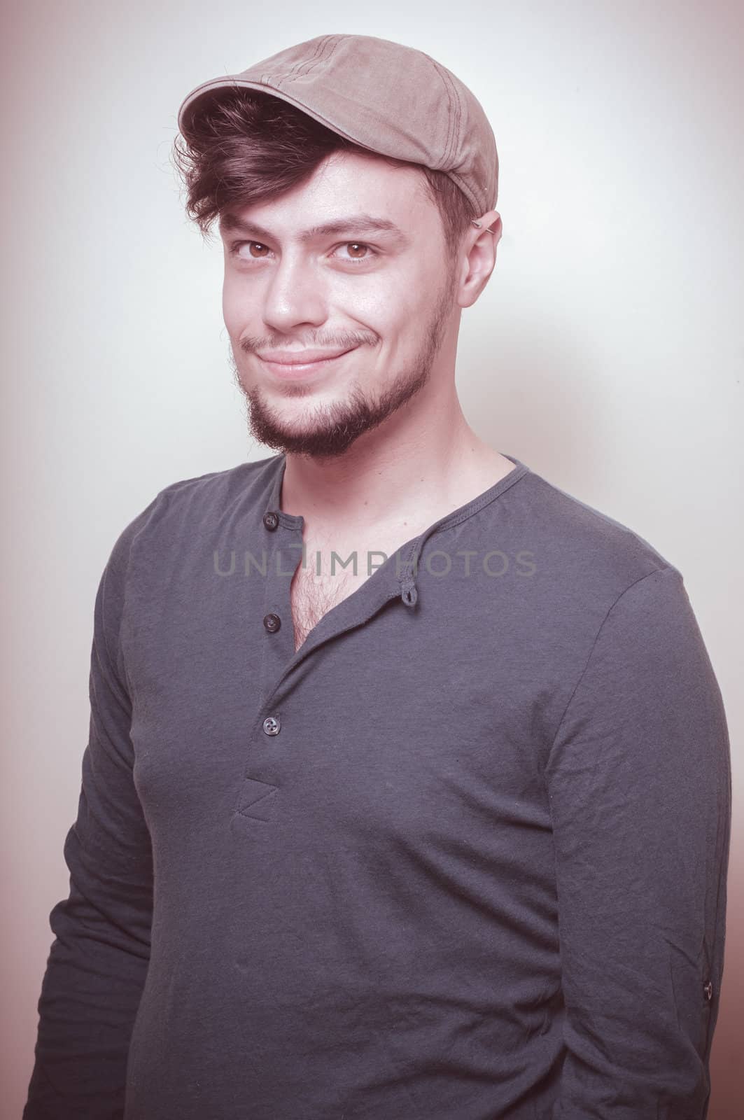 young modern stylish man with cap on vignetting background