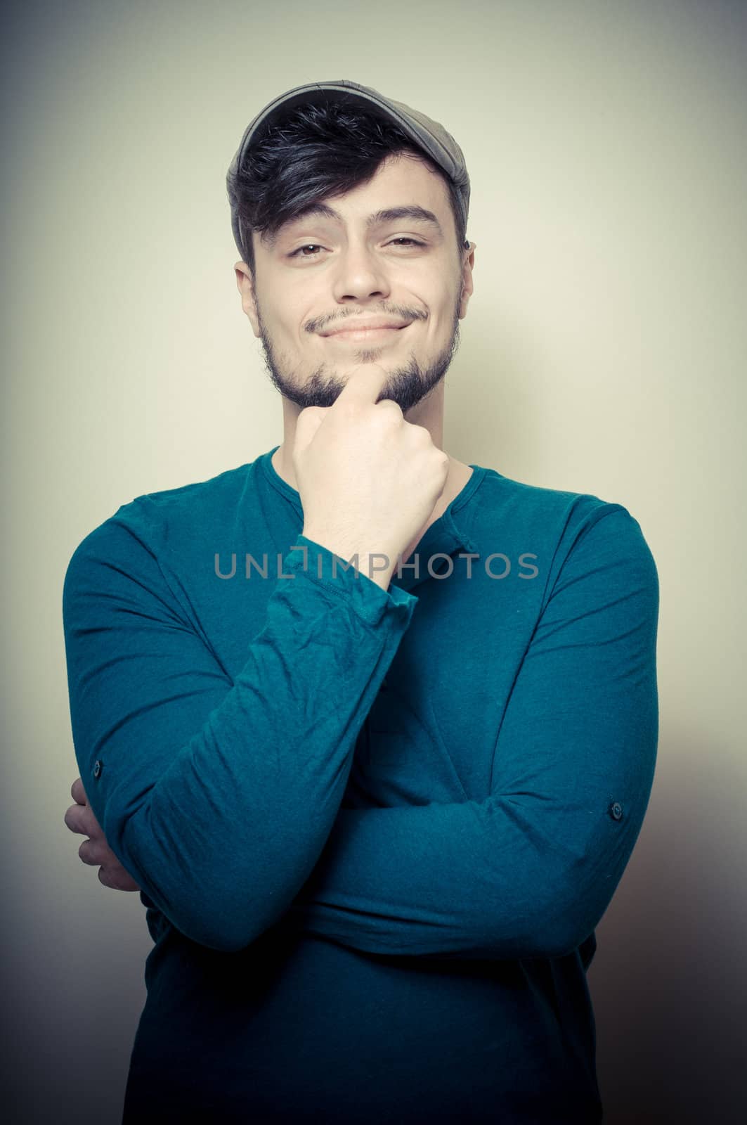 young modern stylish man with cap on vignetting background