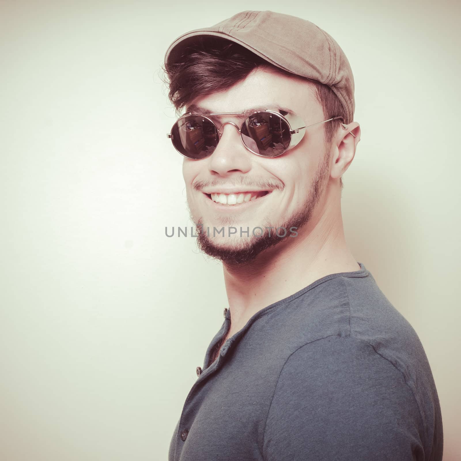 young modern stylish man with cap on vignetting background