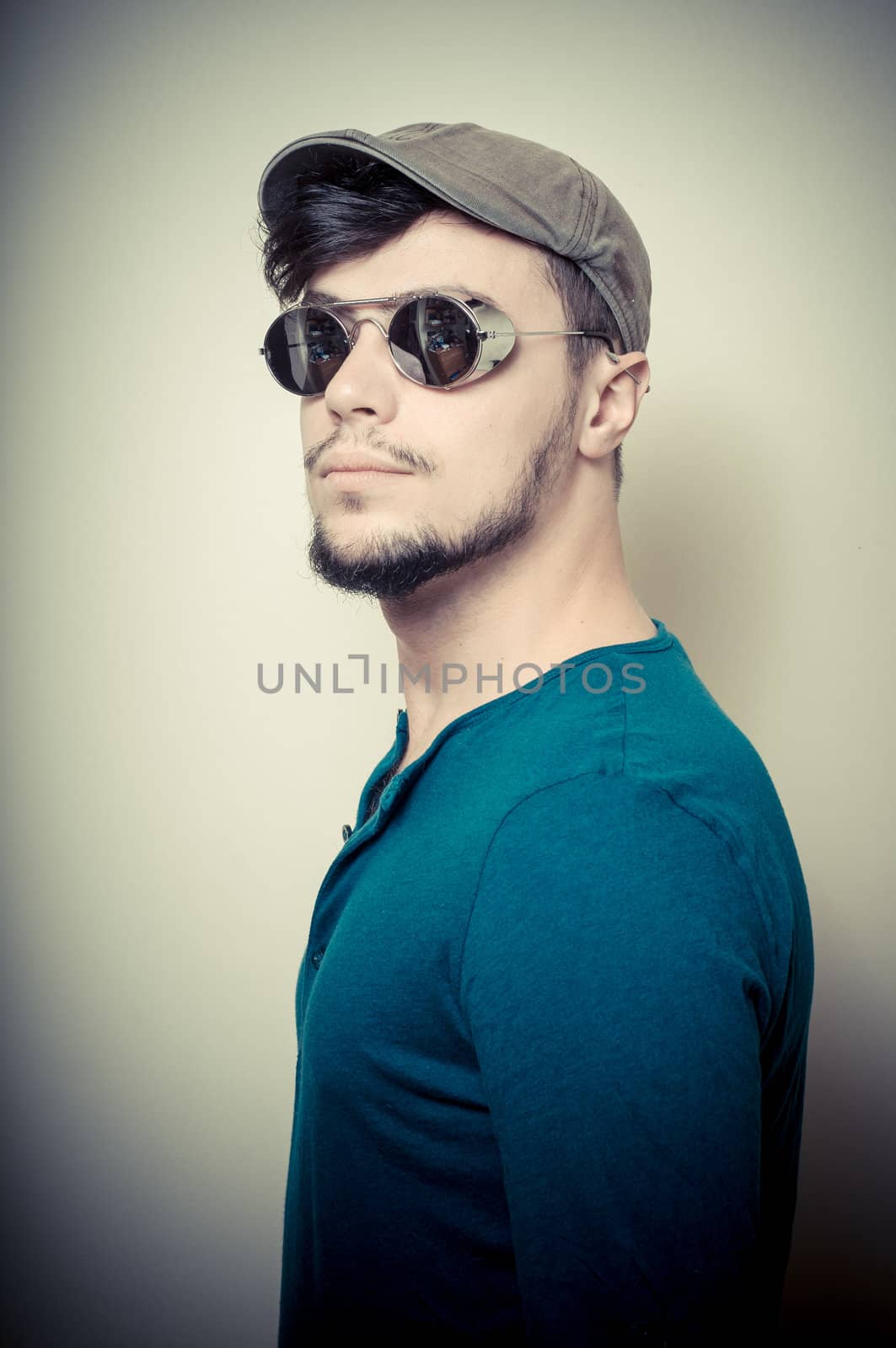 young modern stylish man with cap on vignetting background