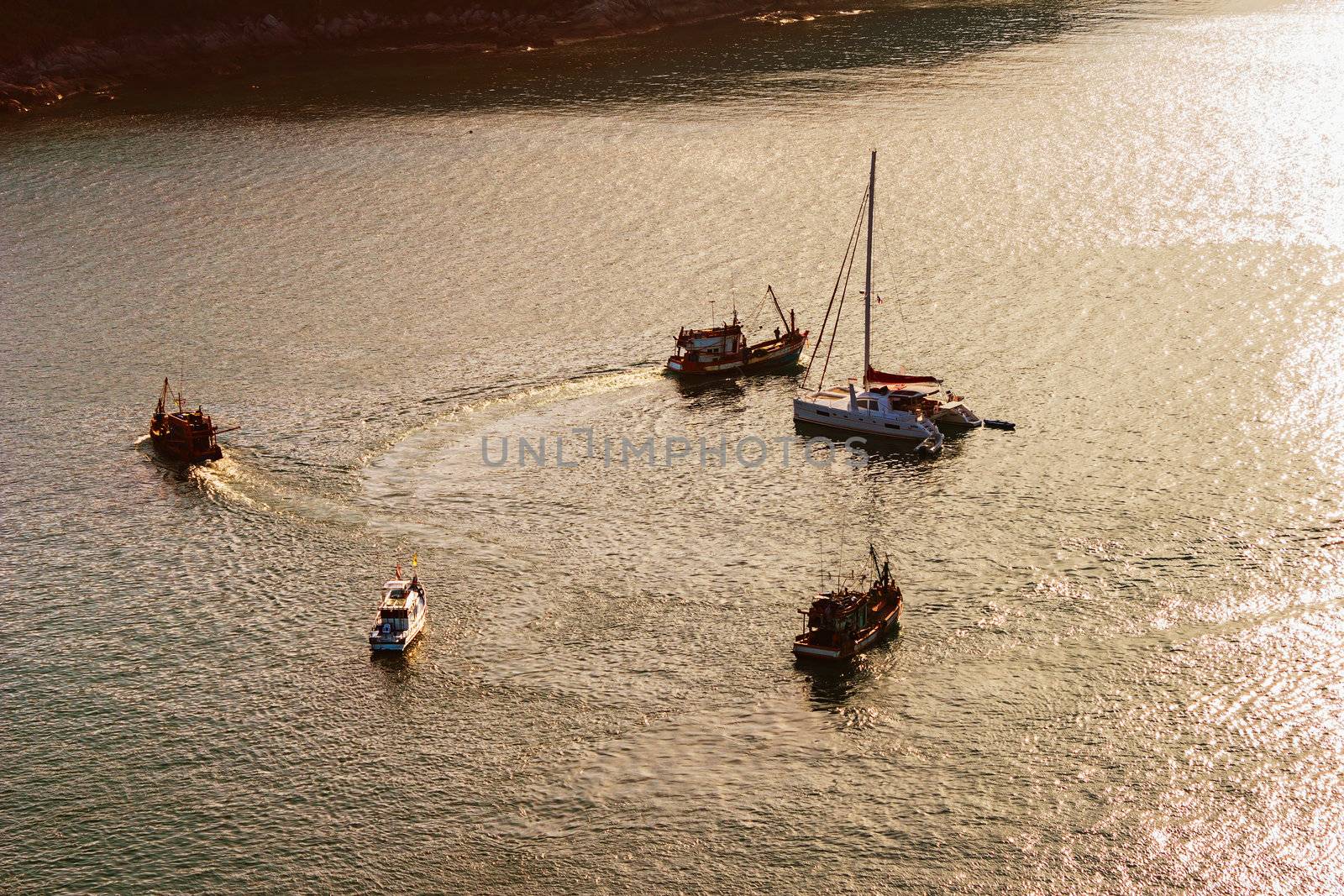 Yachts in the sea at sunset and reflections on the water