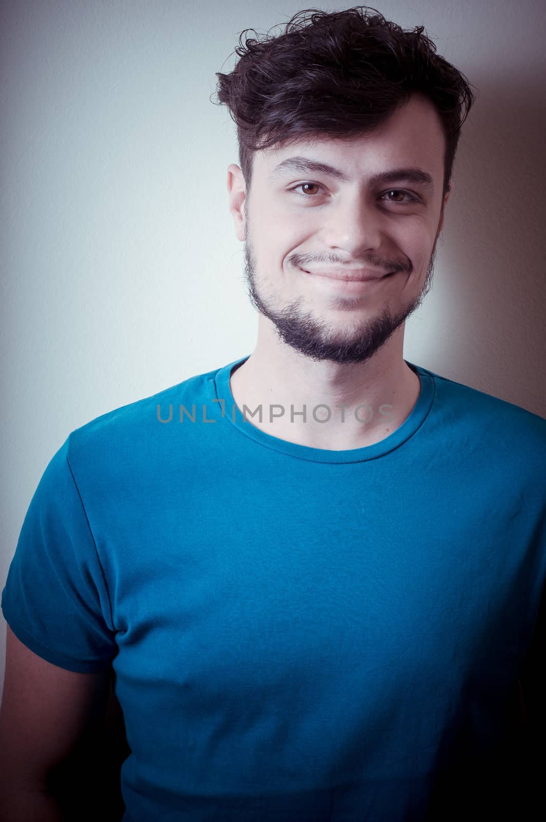 portrait of stylish young man with blue shirt on vignetting background