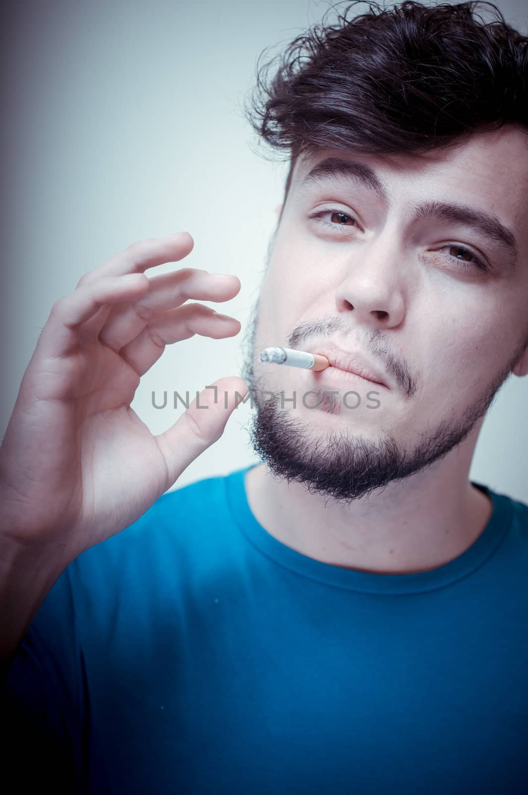 stylish young modern man with cigarette on vignetting background