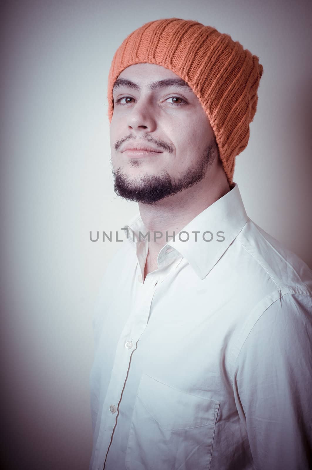 young modern stylish man with orange cap on vignetting background