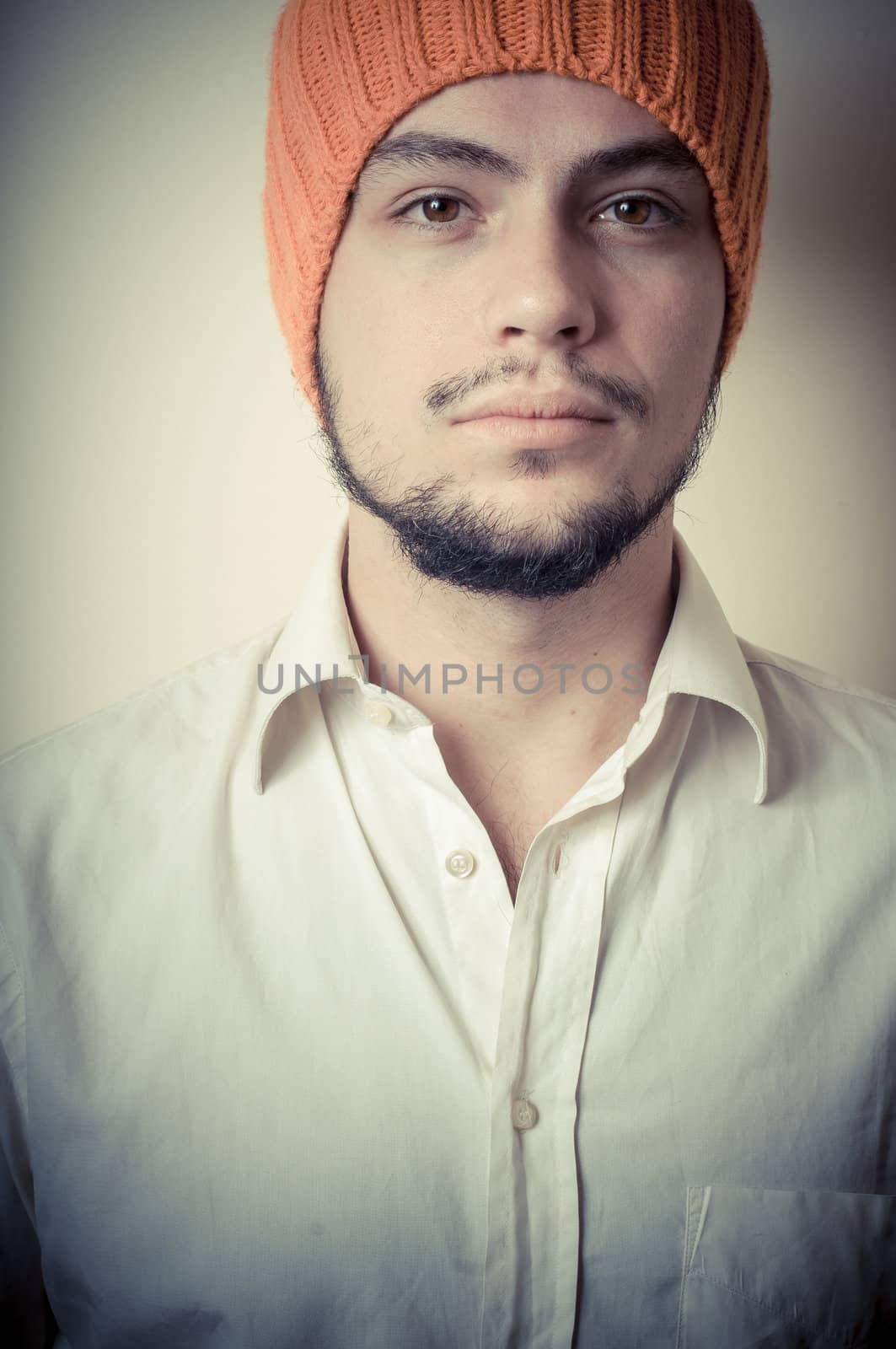 young modern stylish man with orange cap on vignetting background