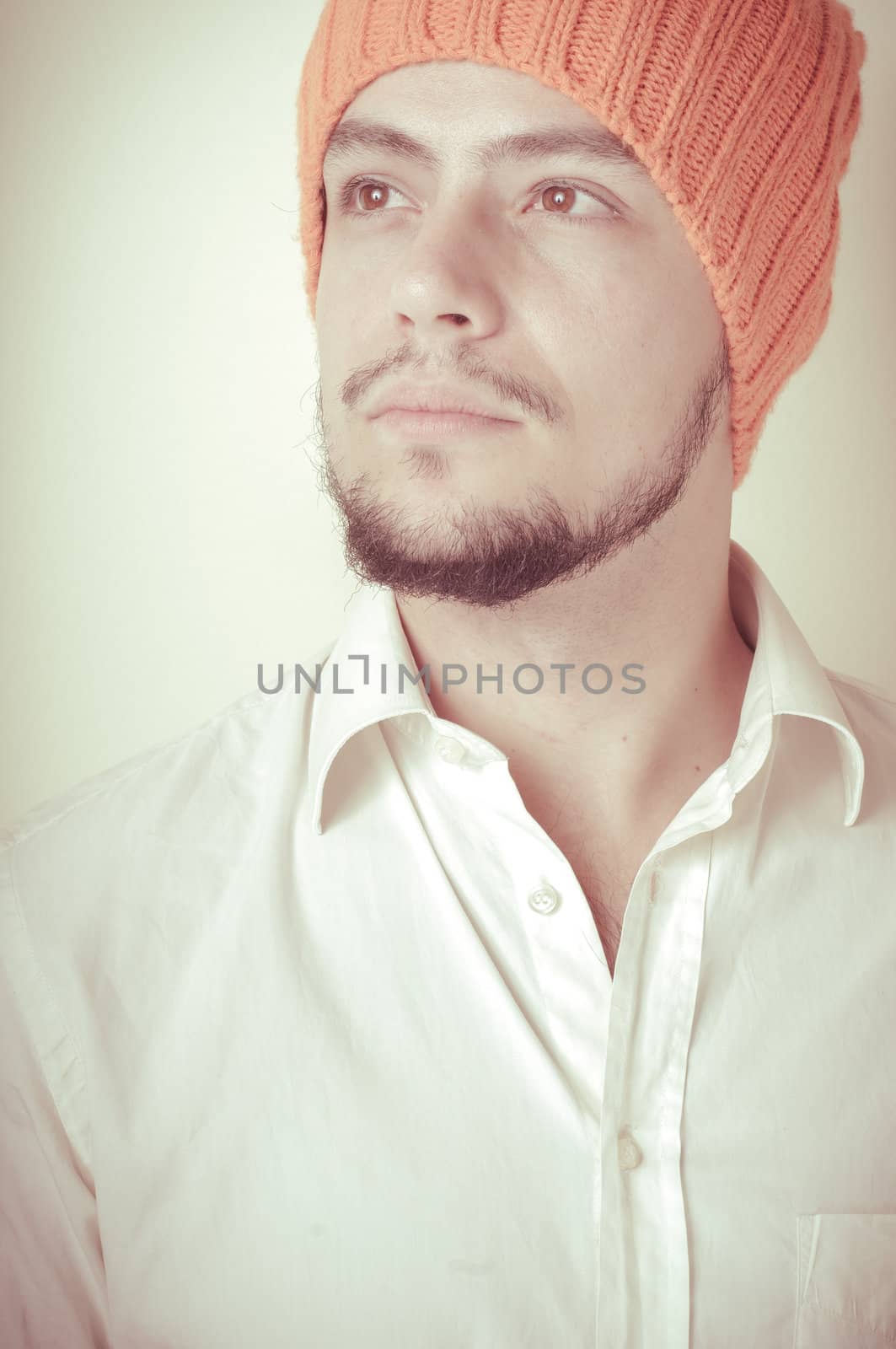 young modern stylish man with orange cap on vignetting background