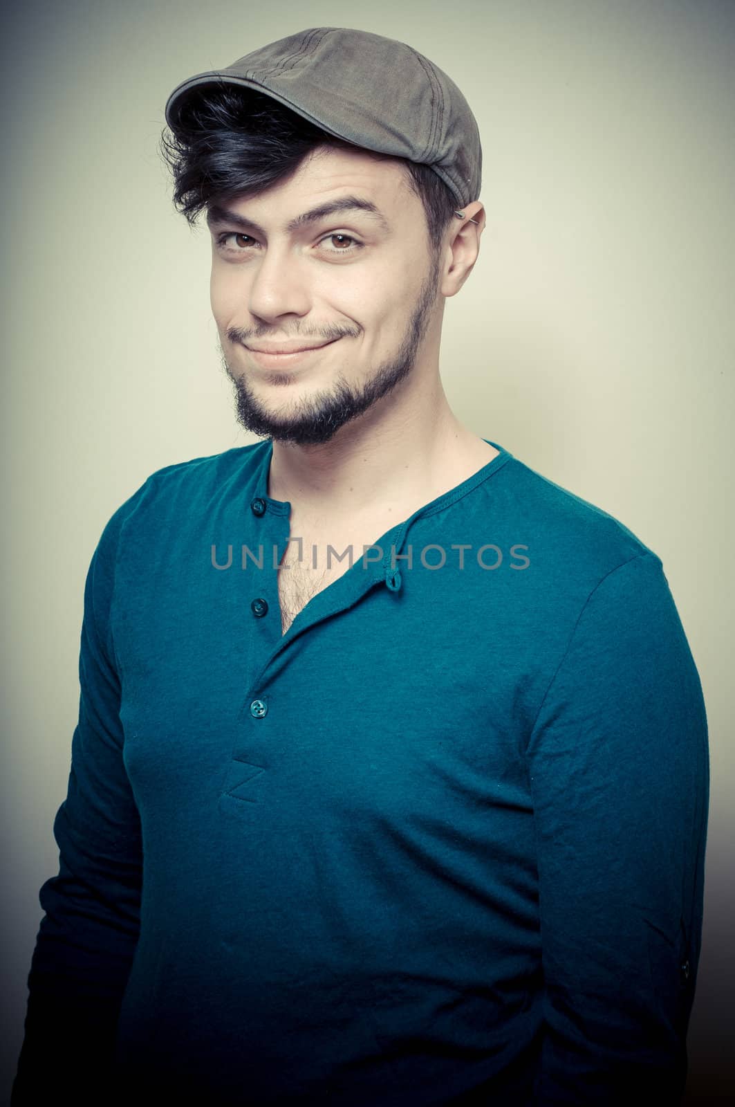 young modern stylish man with cap on vignetting background