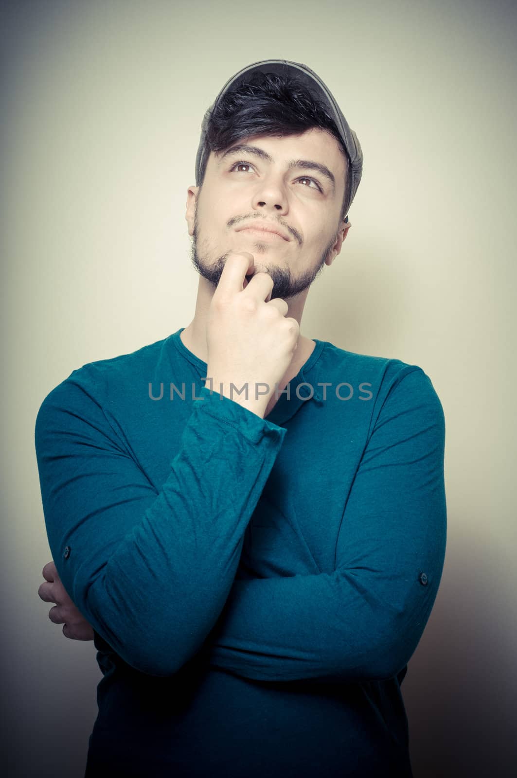 young modern stylish man with cap on vignetting background