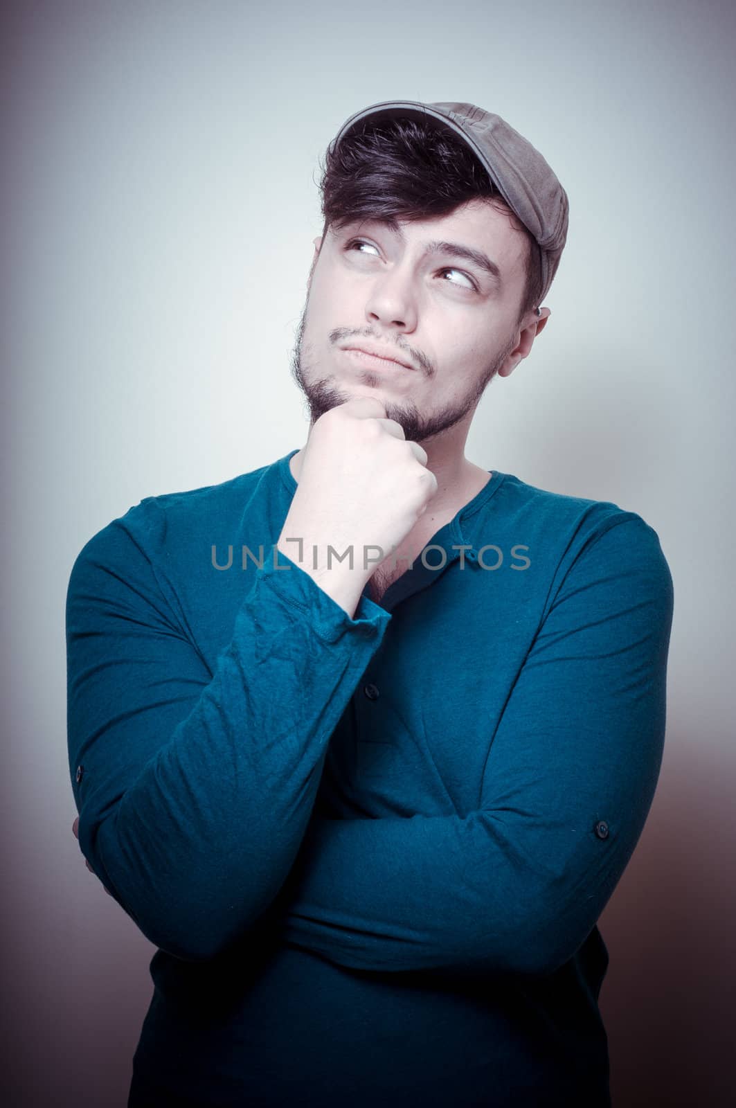 young modern stylish man with cap on vignetting background