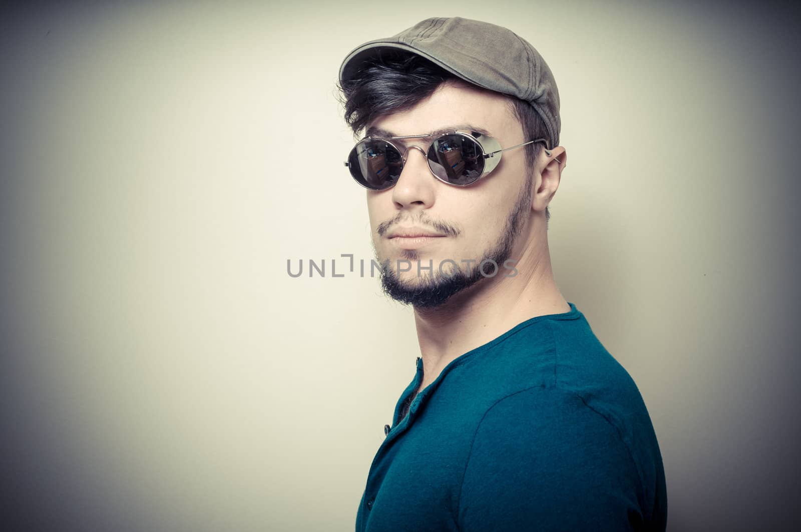 young modern stylish man with cap on vignetting background