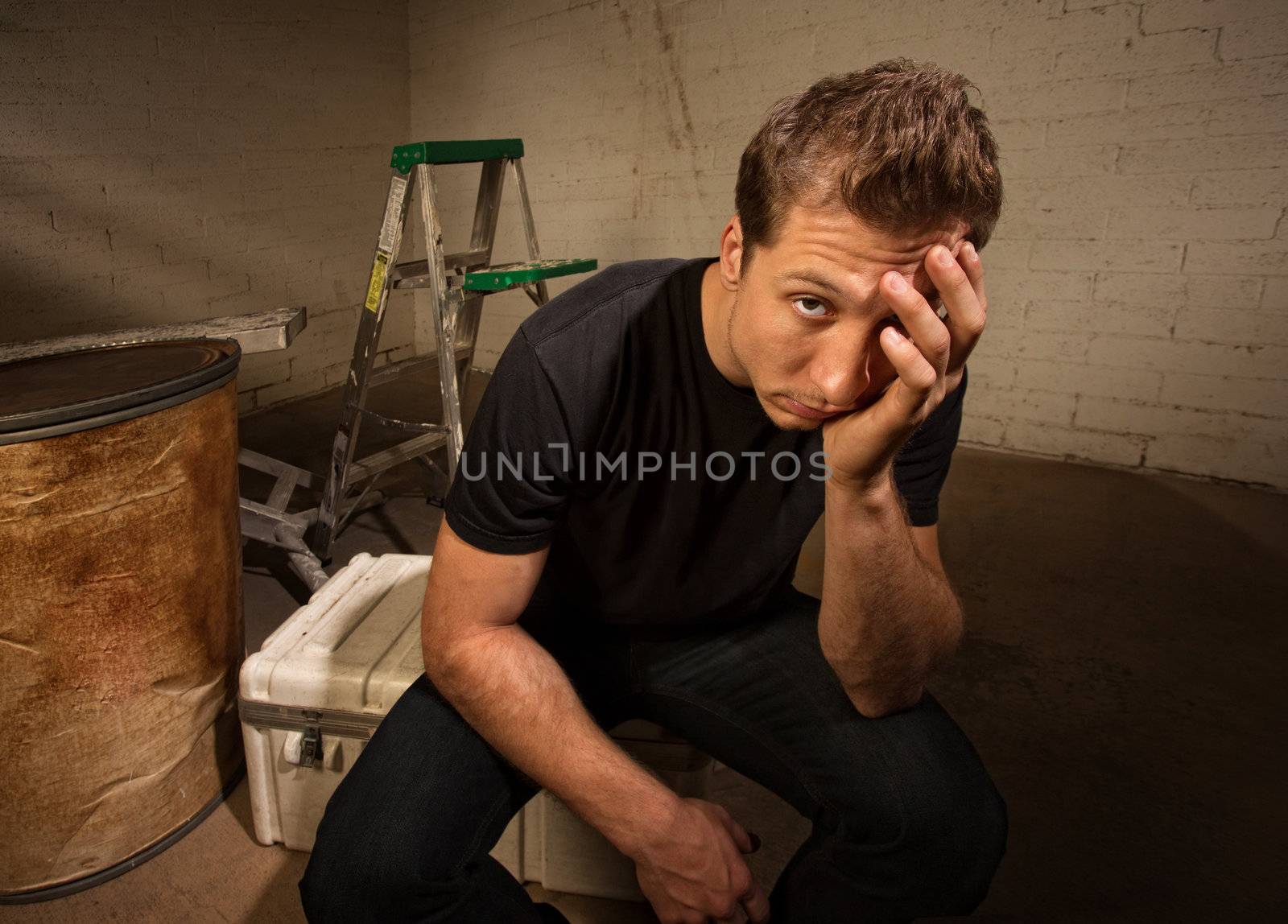 Stressed out European man sitting in warehouse