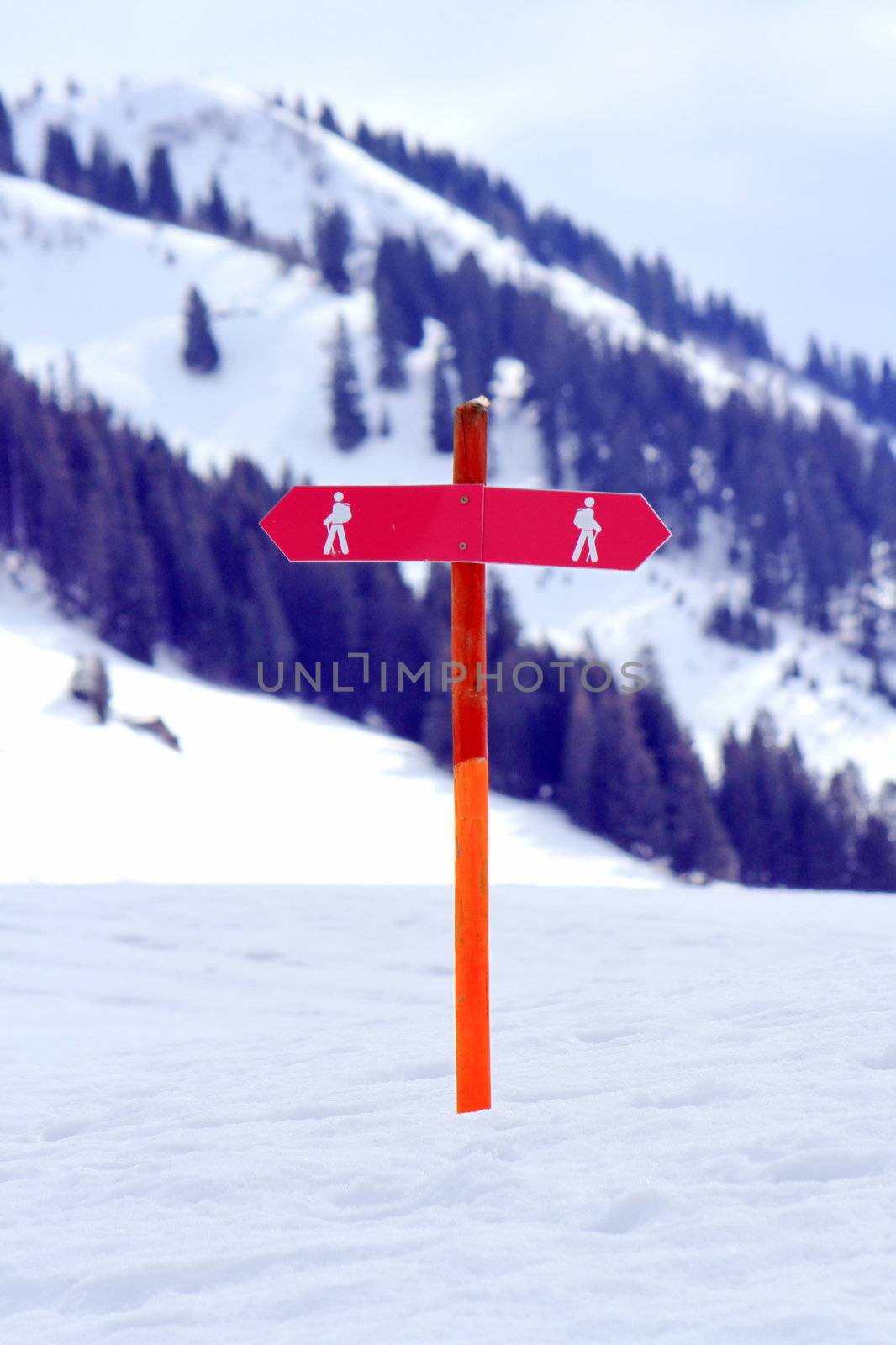 Two red signs for walkers in the snowy mountain