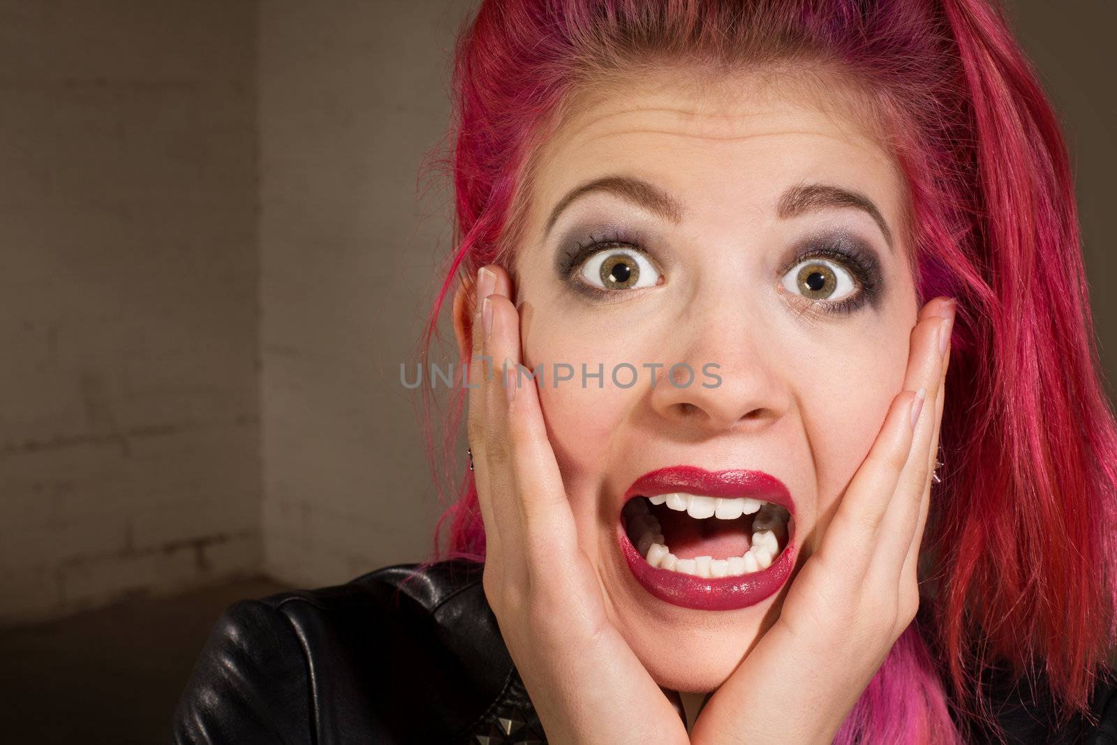 Horrified young punk rocker female in pink hair