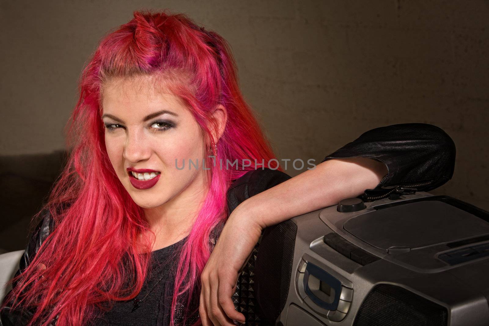 Sneering young adult female leaning on a portable radio