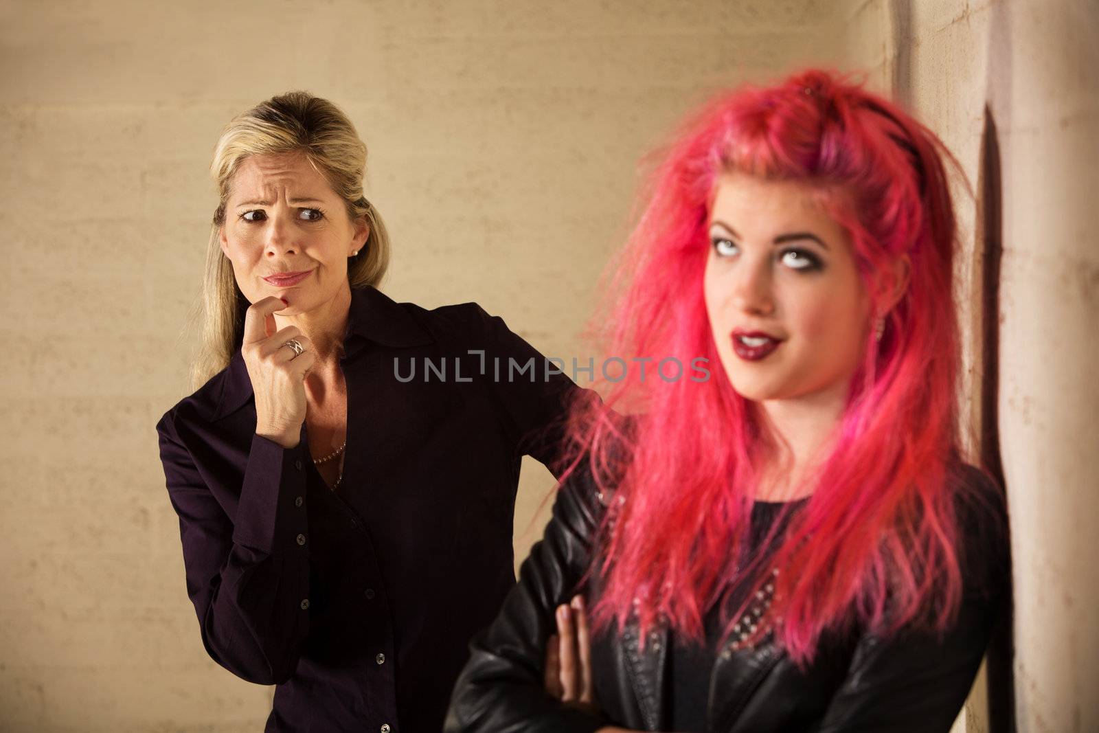 Suspicious blond mother with annoyed teenage daughter