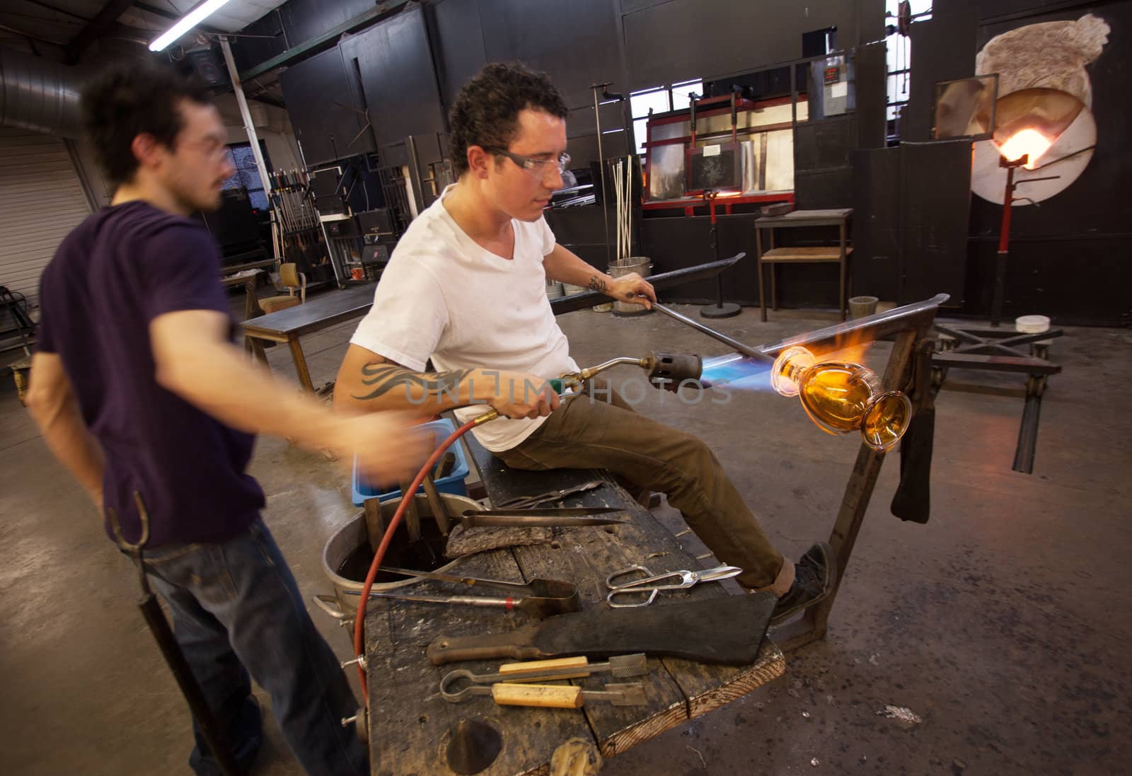 Two glass artists working together with blowtorch