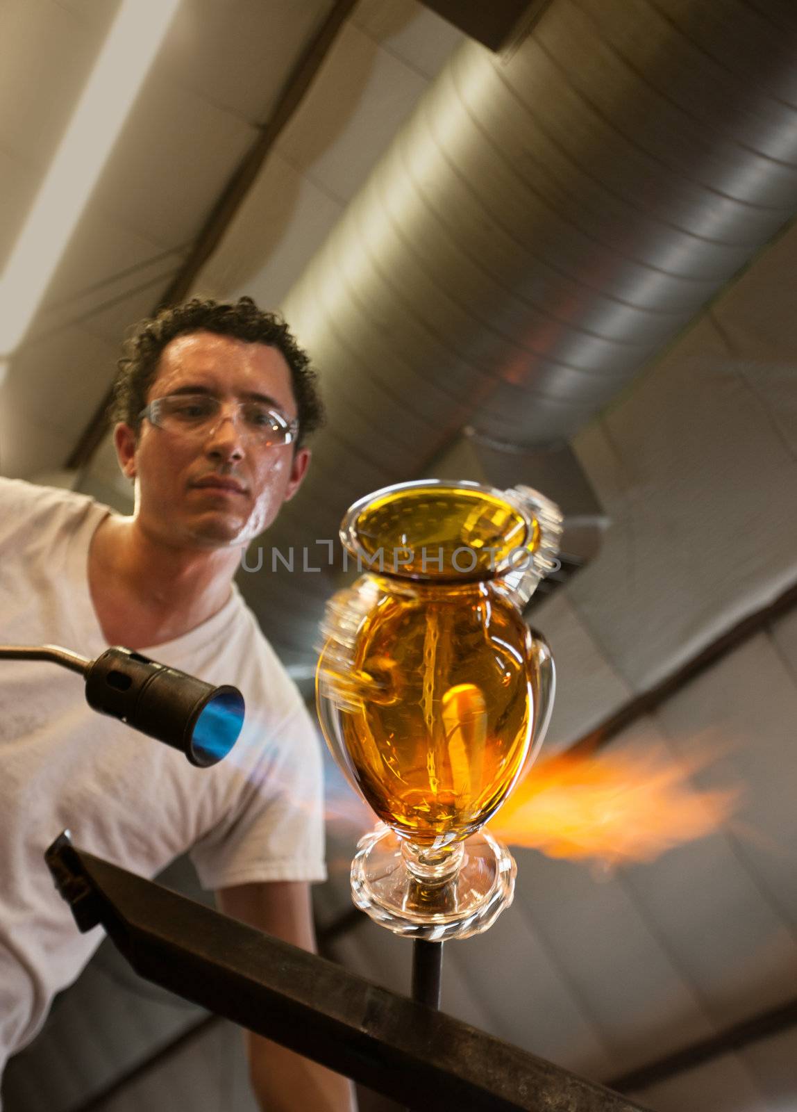 Handsome latino glass artisan finishing a yellow vase