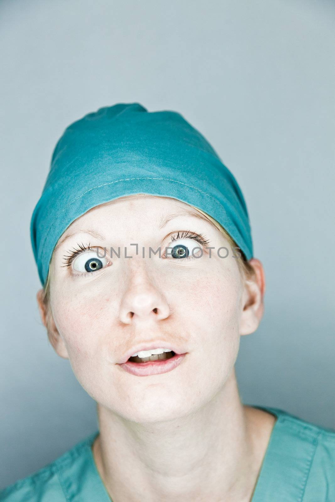 Young nurse in studio on a gray background