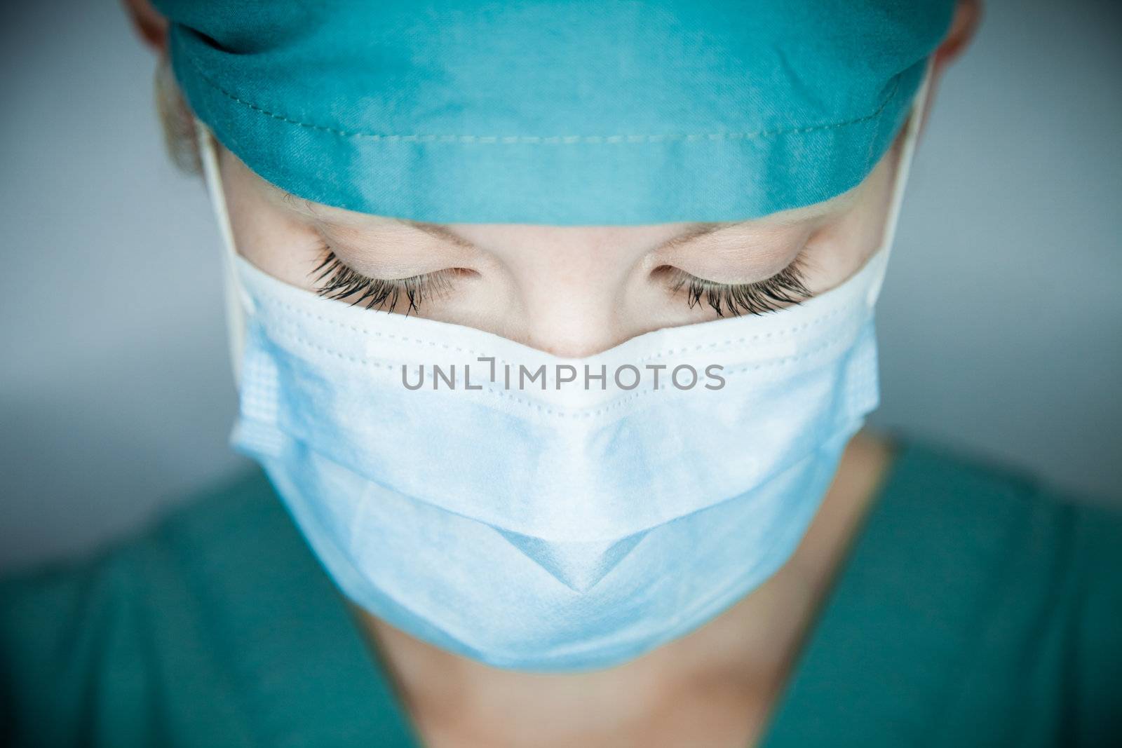 Young nurse in studio on a gray background