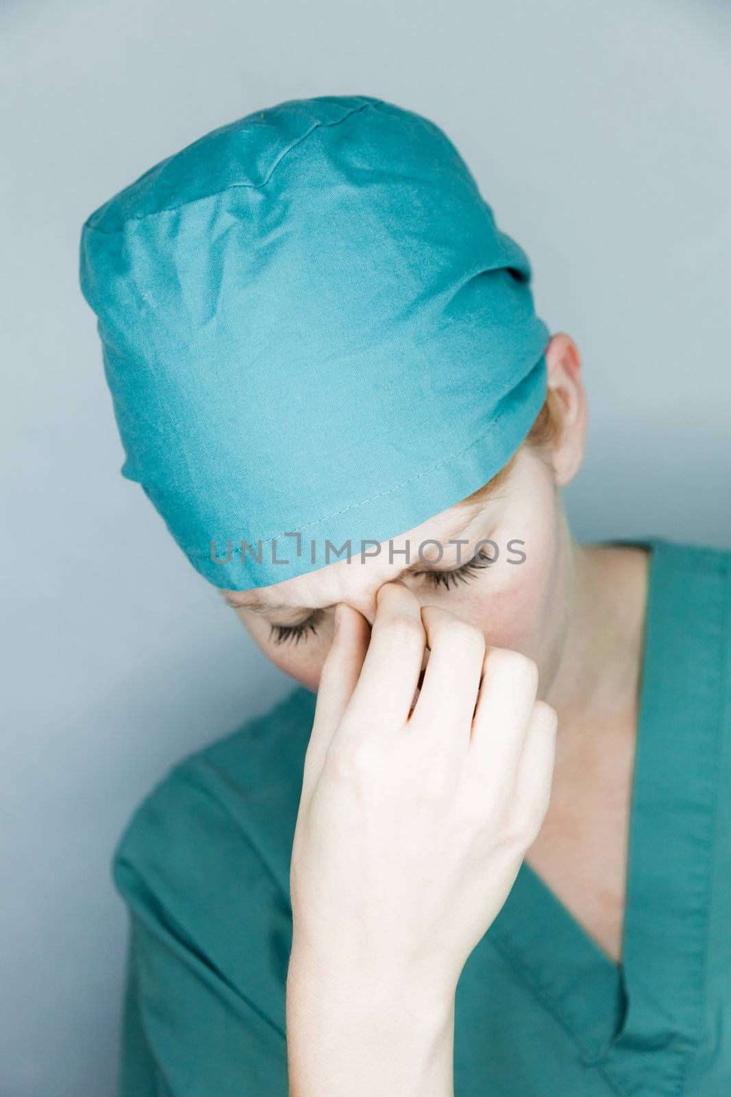 Young nurse in studio on a gray background