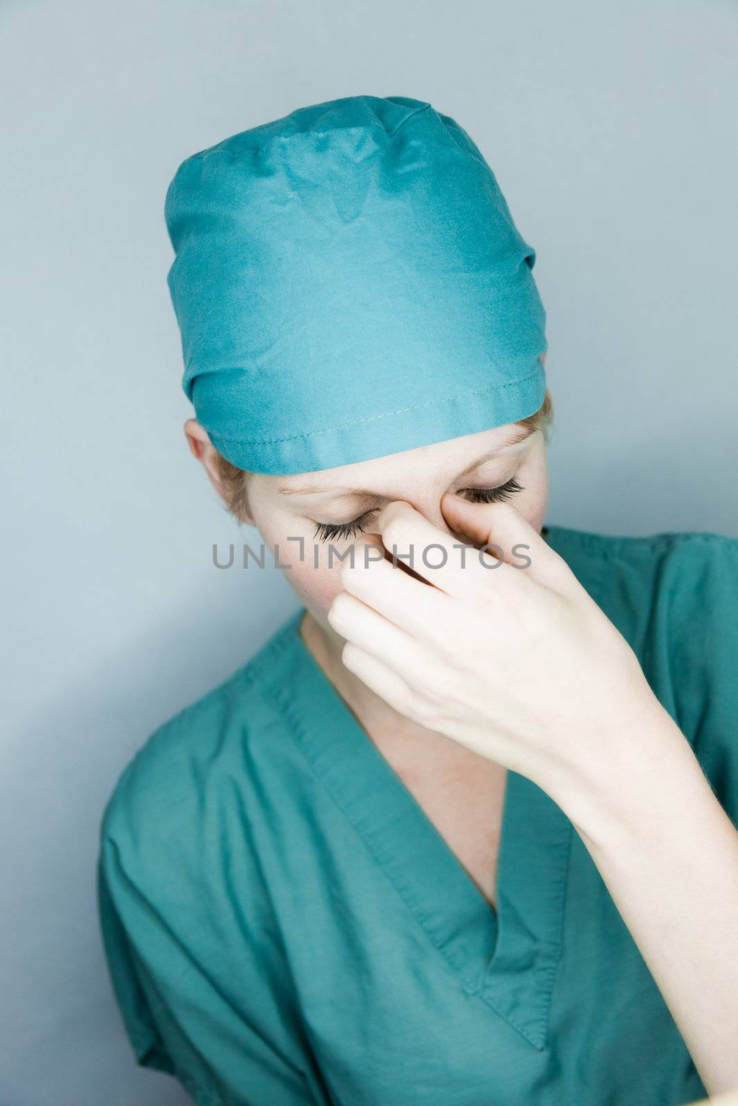 Young nurse in studio on a gray background