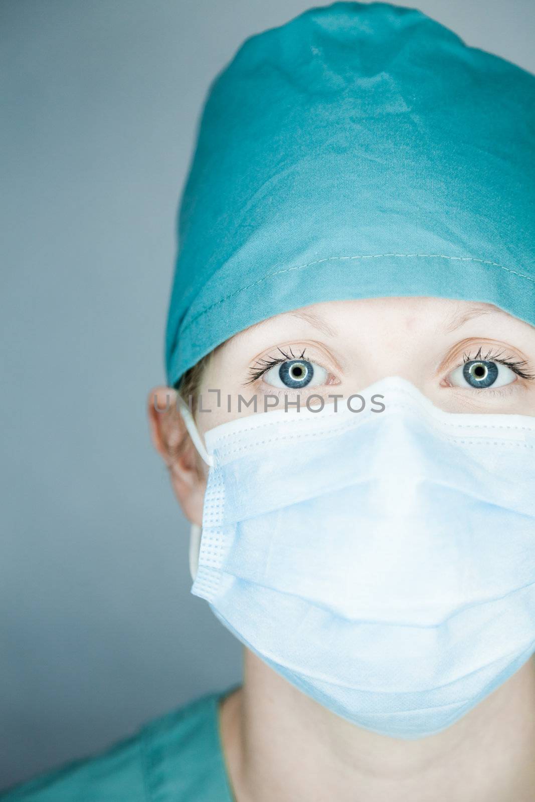 Young nurse in studio on a gray background