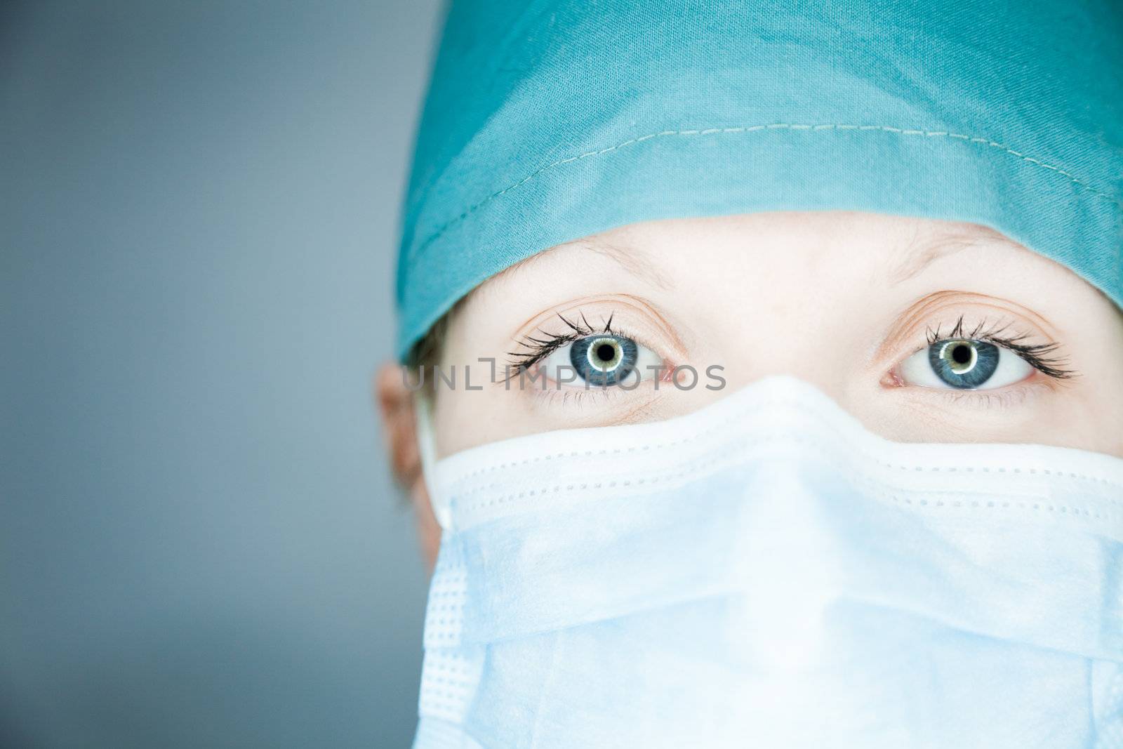 Young nurse in studio on a gray background