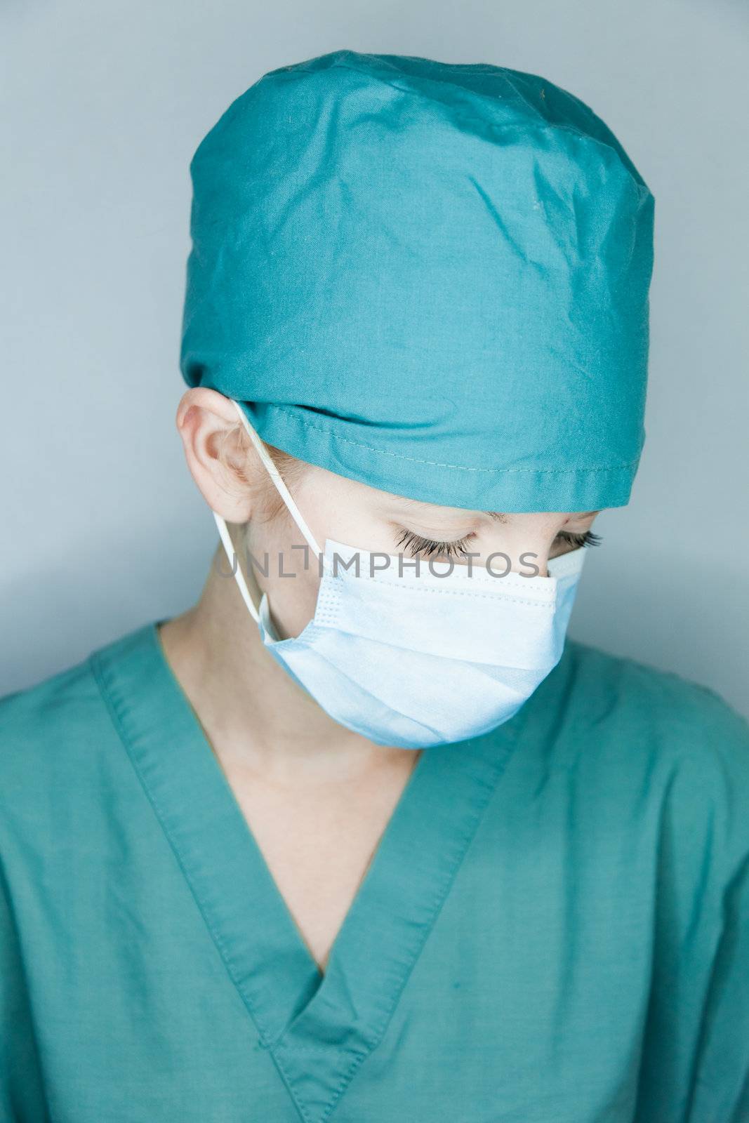 Young nurse in studio on a gray background