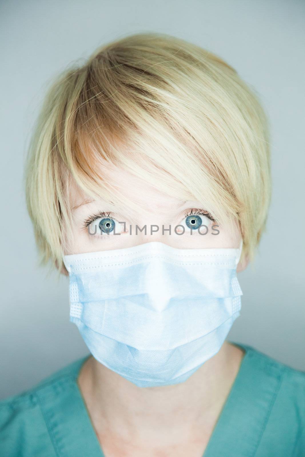 Young nurse in studio on a gray background