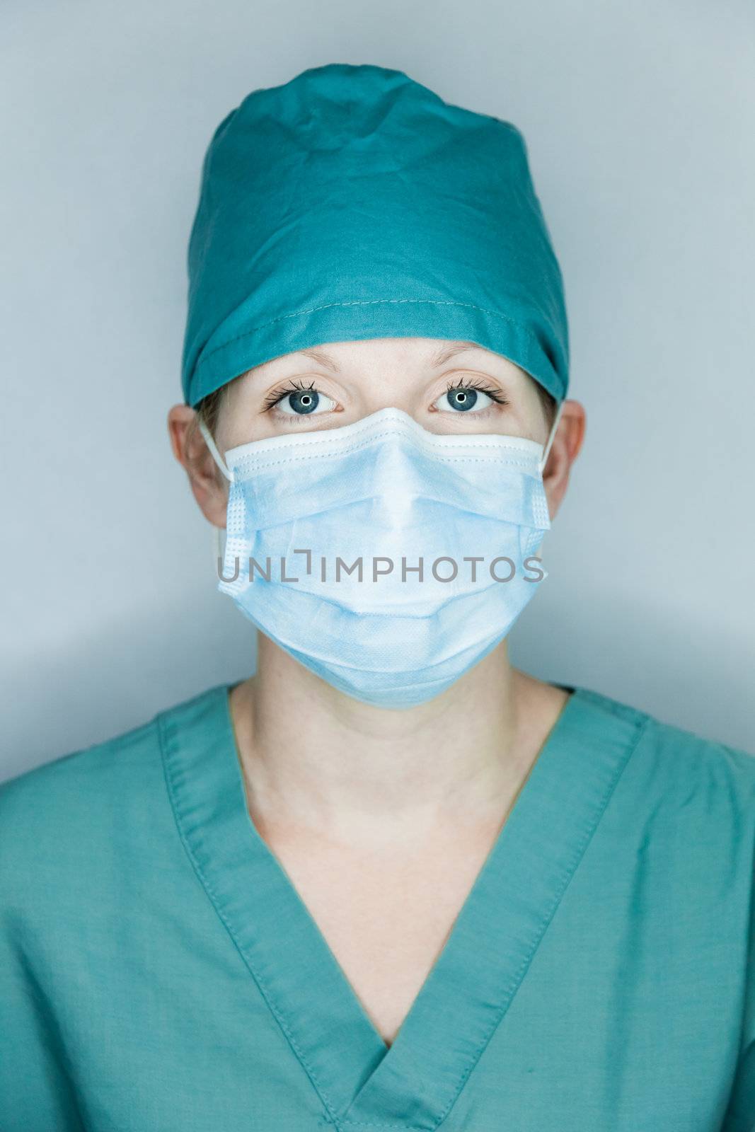 Young nurse in studio on a gray background