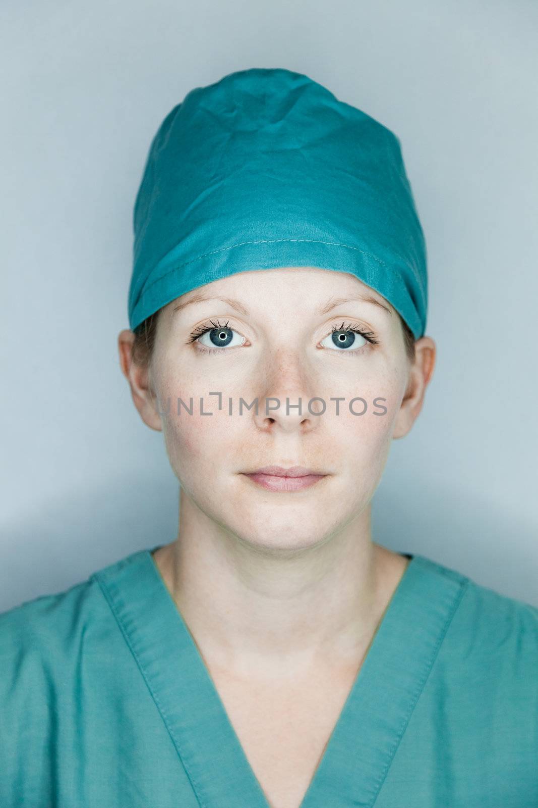 Young nurse in studio on a gray background