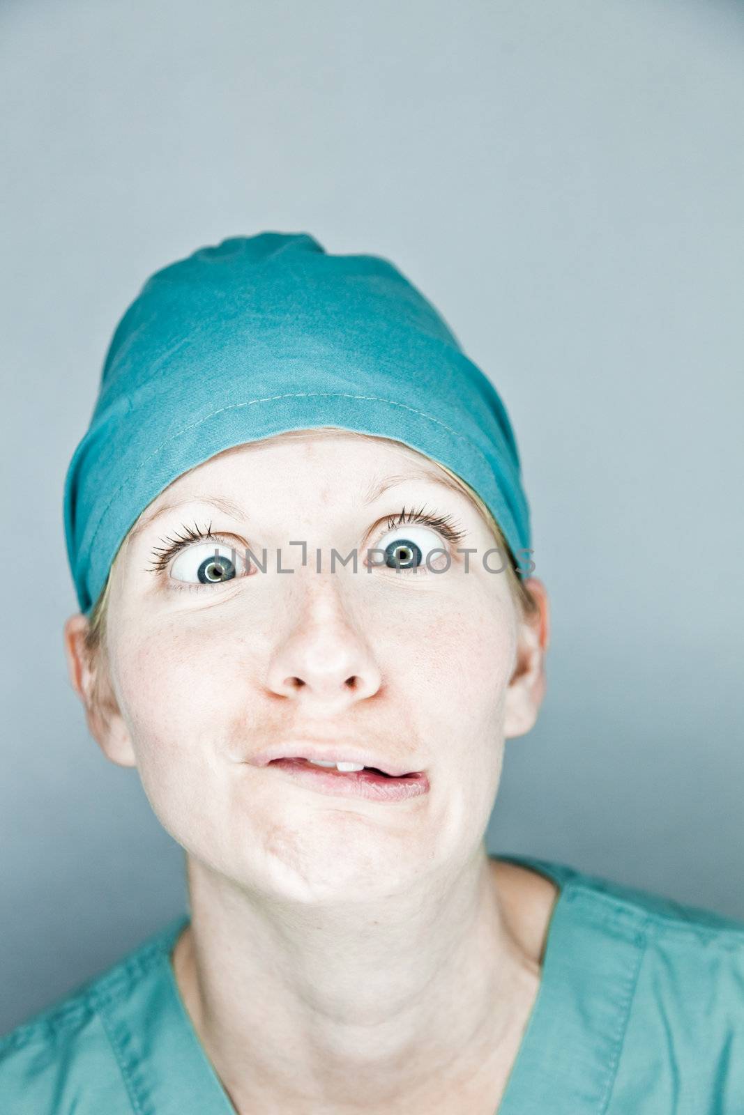 Young nurse in studio on a gray background