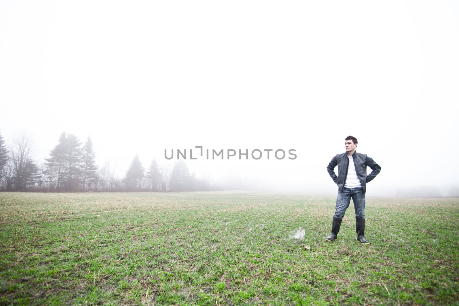 Young adult in a foggy and wet field