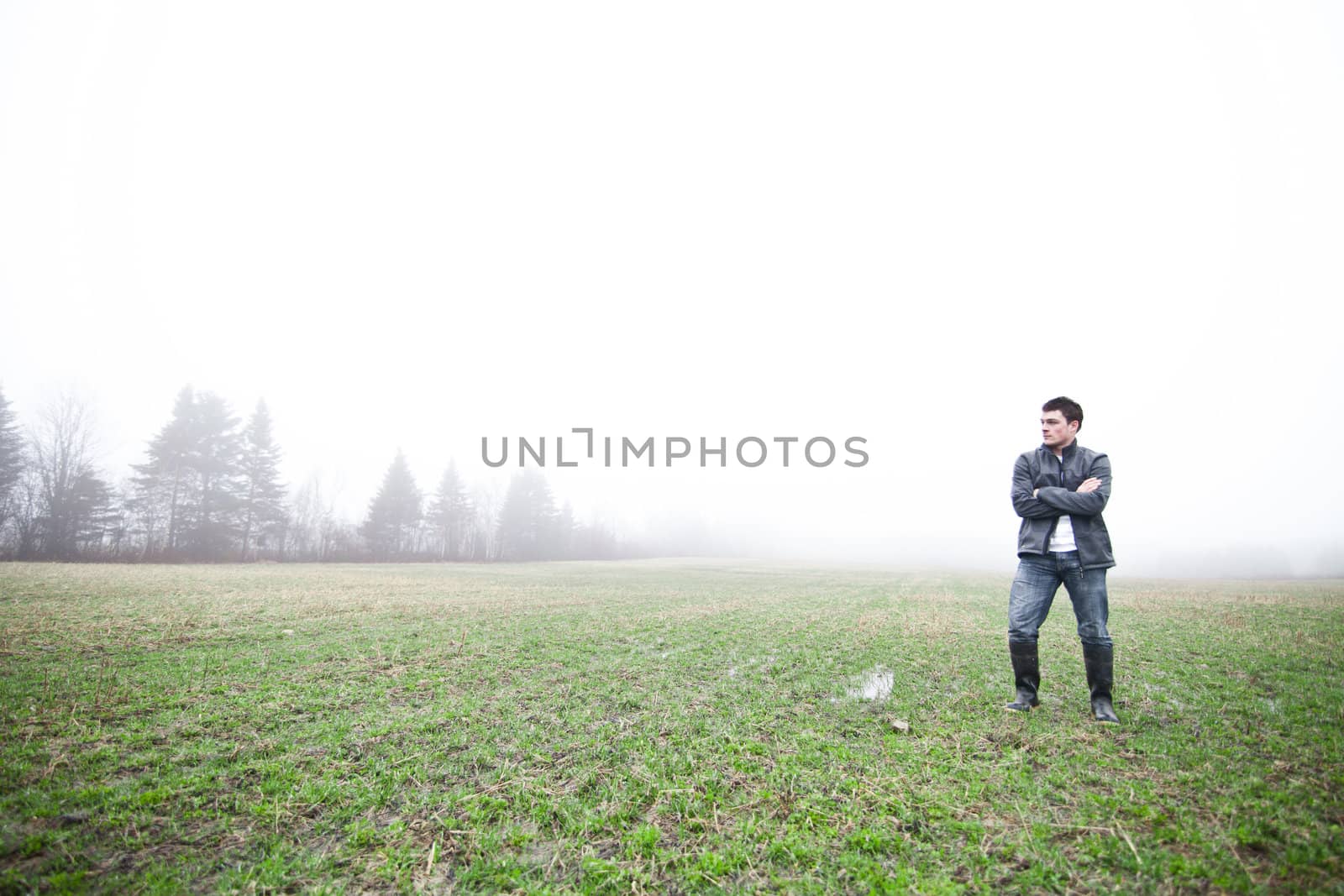 Young adult in a foggy and wet field