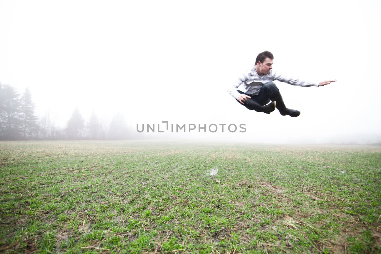 Young adult in a foggy and wet field