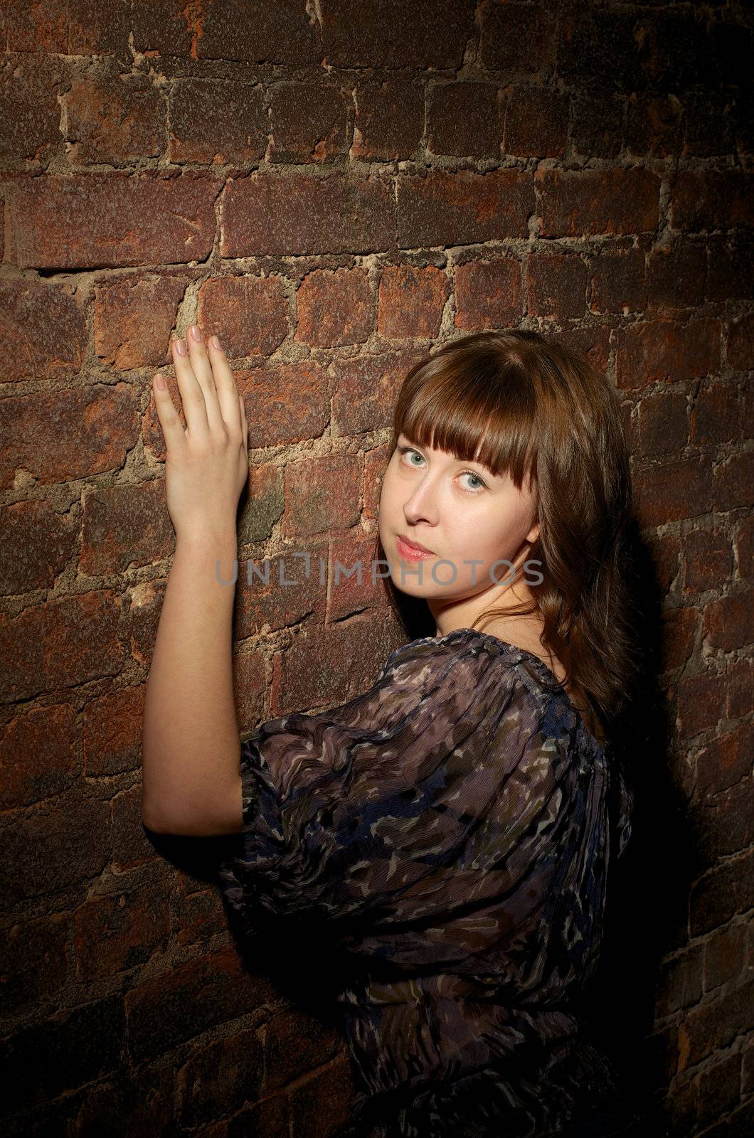 Attractive Young Woman with Long Ginger Hair near Brick Wall