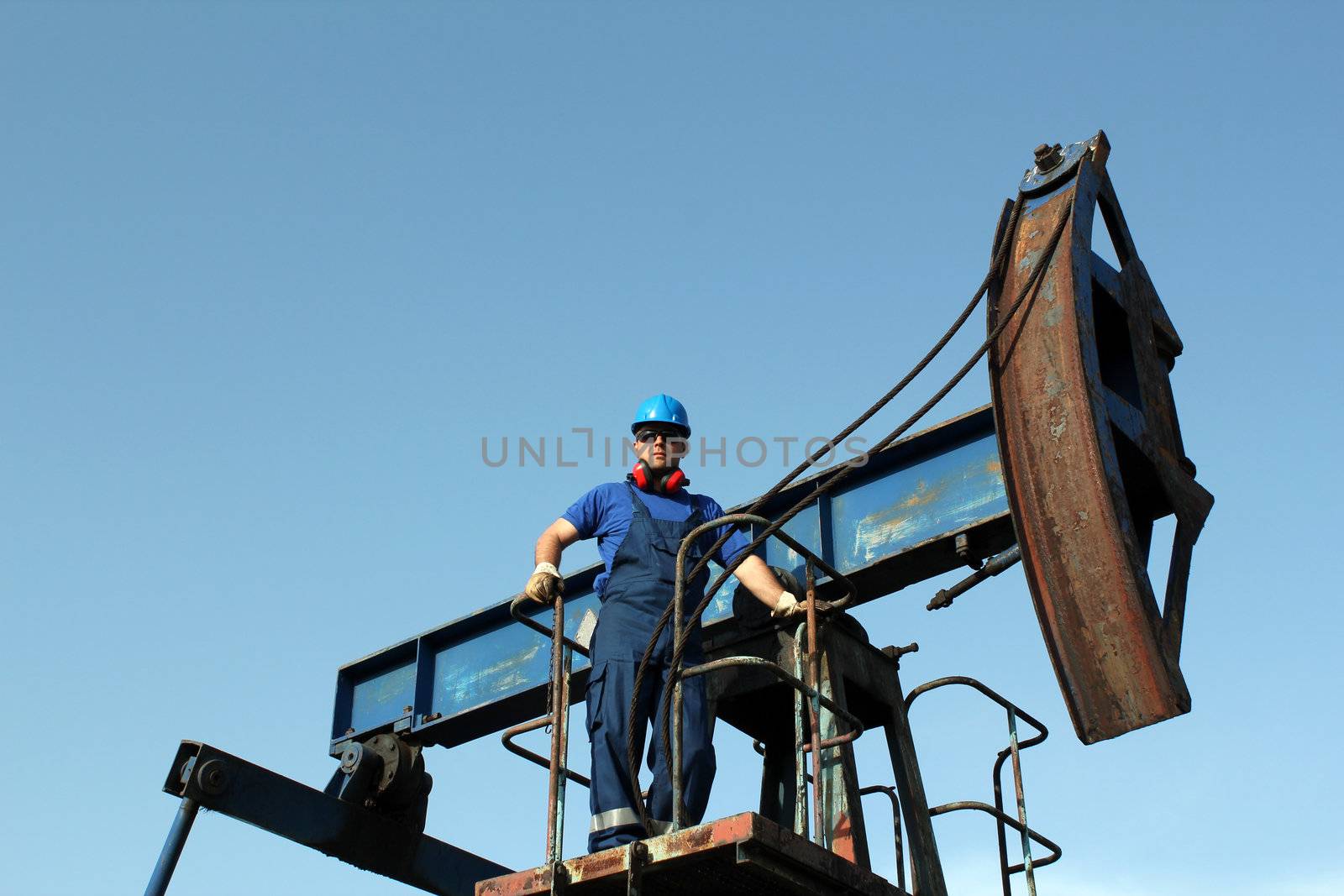 oil worker standing on pump jack