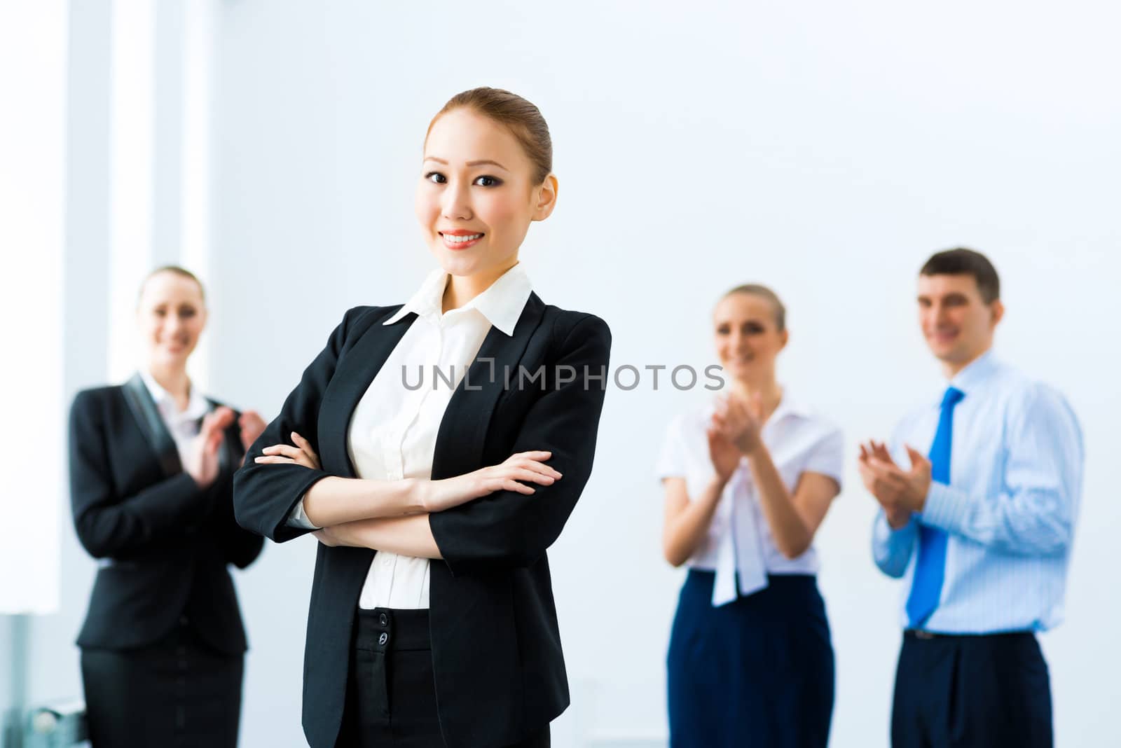 successful business woman in the office, around applauding colleagues