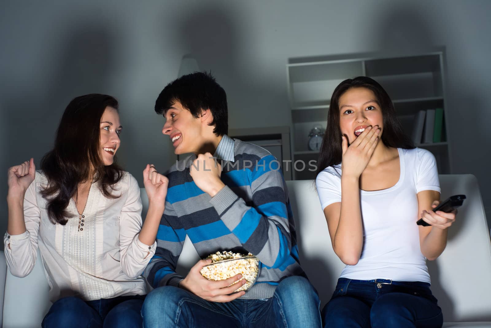 group of young people watching TV on the couch, sports fans